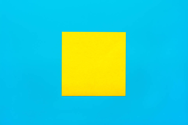 Reminder and combination concept- Close up one yellow empty square sticker on blue background with copy spase, mock up horizontal orientation - Fotó, kép