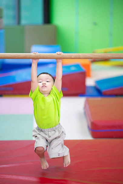 Little toddler boy working out at the indoor gym excercise - Foto, Bild