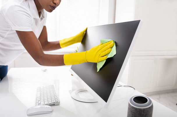 Close-up Of A Woman's Hand Cleaning Desktop Screen With Green Rag In Office - Фото, зображення