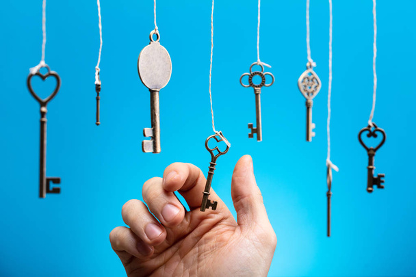 Close-up Of Person's Hand Choosing A Hanging Key Amongst Other Ones - Фото, зображення