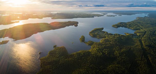 Suoyarvi Lake bij zonsondergang omringd door bossen van Karelië - Foto, afbeelding