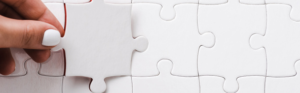 panoramic shot of woman holding white jigsaw near connected puzzle pieces - Photo, Image