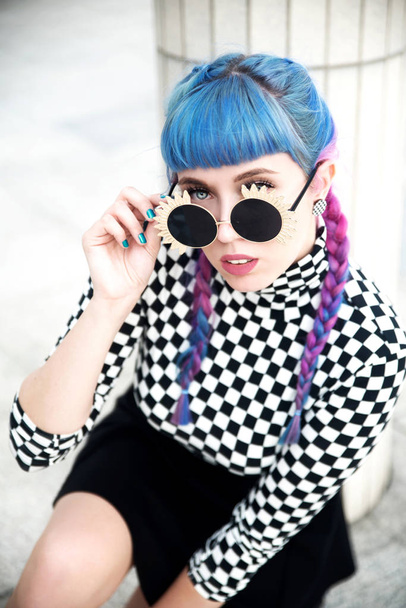Portret van mooie jonge vrouw met blauw haar dragen zonnebril - Foto, afbeelding