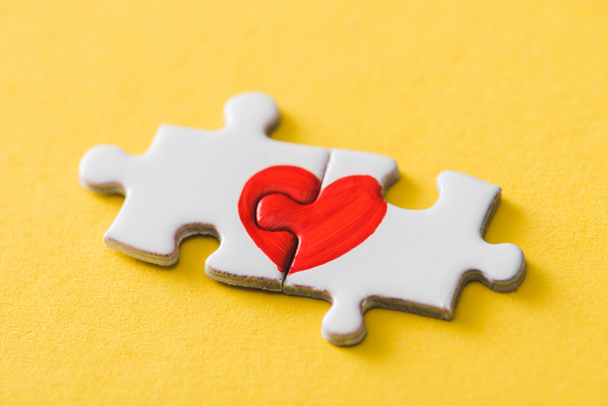 pièces de puzzle connecté avec coeur rouge dessiné sur jaune
  - Photo, image