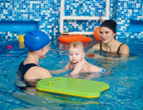 Feliz bebé niño riendo disfrutando de su primera natación en la piscina infantil
 - Foto, imagen