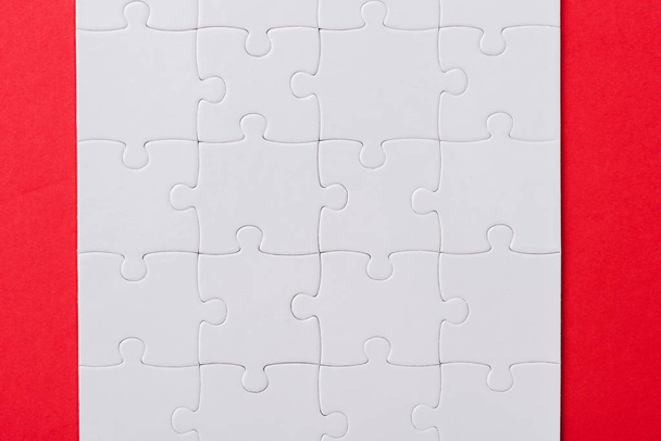 top view of set with white jigsaw puzzle pieces isolated on red  - Foto, Imagen
