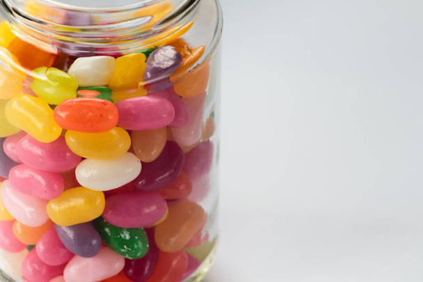 Jelly beans in glass jar on white background - Foto, Bild