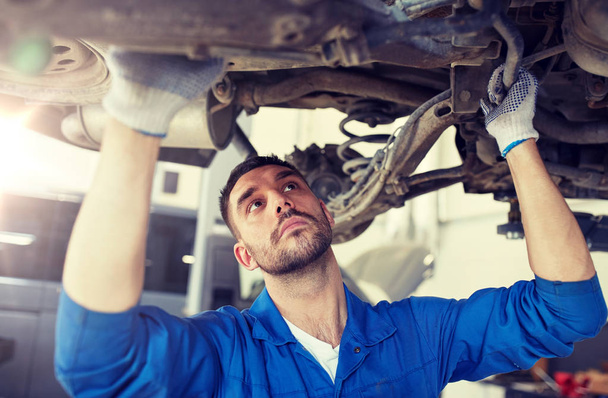 mechanic man or smith repairing car at workshop - Photo, image