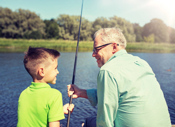 grandfather and grandson fishing on river berth - Foto, Imagem