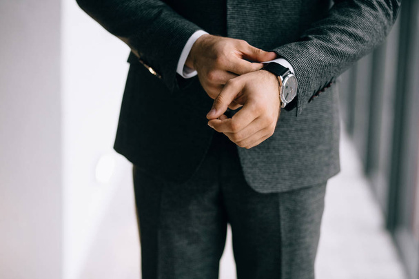 cropped shot of groom in suit wearing wrist watch - Foto, Imagen