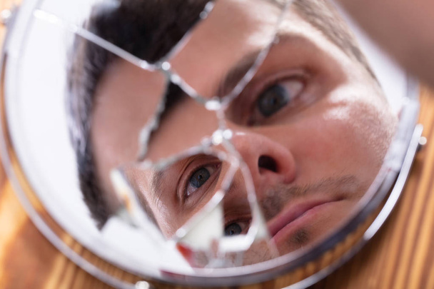 Close-up Of Young Man Looking At His Face In A Broken Mirror - Photo, Image