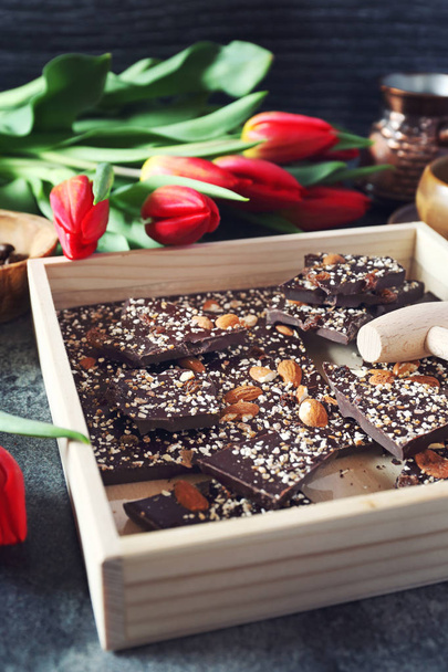 Holiday mood. Dark  chocolate with nuts, coffee and red tulips - Photo, Image