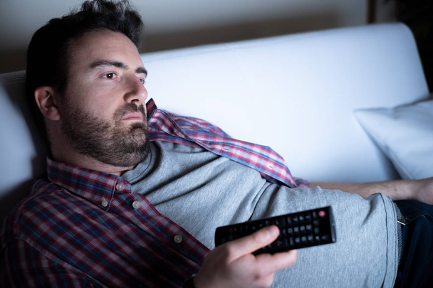 Lazy man watching television at night alone - Photo, Image