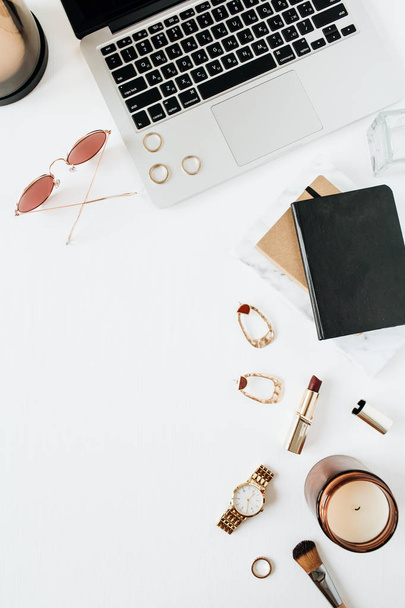 Feminine modern home office desk workspace with laptop, watch, lipstick, sunglasses, accessories on white background. Flat lay, top view. Fashion blog, social media, website minimal composition. Girl boss concept. - Foto, Imagen