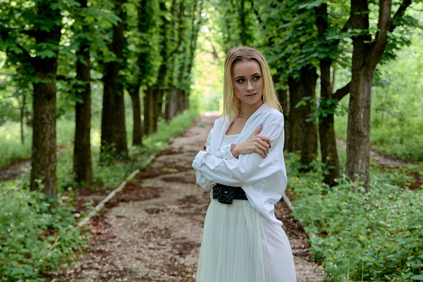 Die blonde Frau läuft allein die Kastanienallee im Stadtpark entlang. junge Frau modernes Porträt. - Foto, Bild