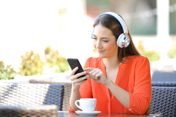Zrelaksowany kobieta słuchanie muzyki w kawiarni - Zdjęcie, obraz