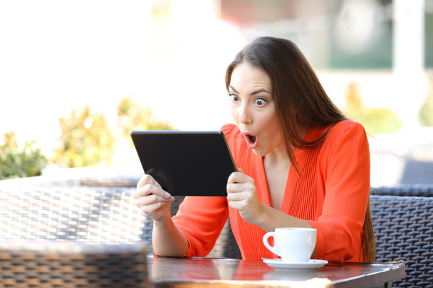 Shocked woman watching and listening media on tablet - Fotografie, Obrázek