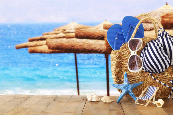 Urlaub und Sommer Konzept mit Sea Life Style Objekten über Holztisch vor Meereslandschaft Hintergrund - Foto, Bild