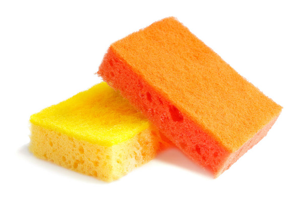 Esponjas coloridas para lavar pratos e outras necessidades domésticas. A esponja alaranjada encontra-se na esponja amarela em um ângulo ligeiro com o lado abrasivo para cima. isolar
 - Foto, Imagem