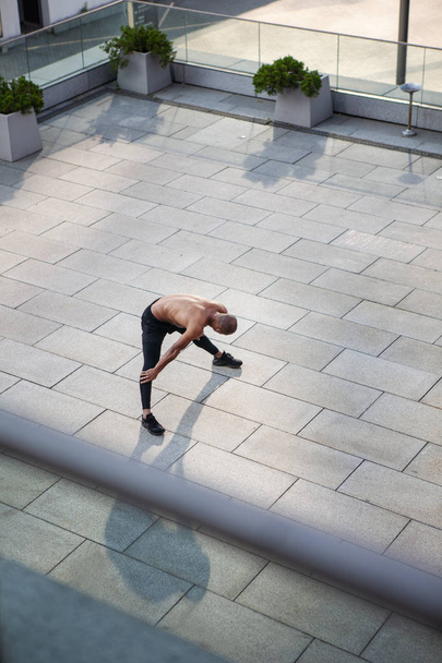 Красивый молодой человек делает упражнения на растяжку
 - Фото, изображение