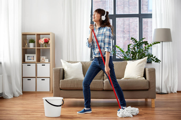 happy asian woman with mop cleaning floor at home - Photo, Image