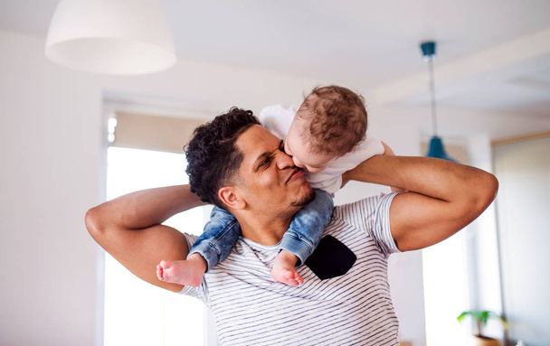 Father and small toddler son indoors at home, playing. - Foto, imagen