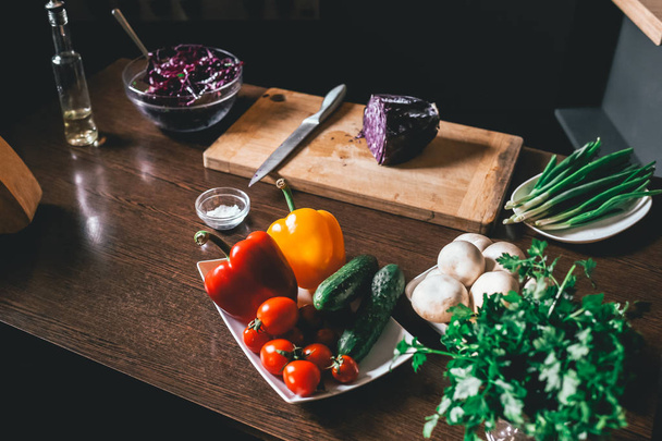 Kool salade en verse groenten liggen op tafel. Vegetarische en gezonde levensstijl. - Foto, afbeelding