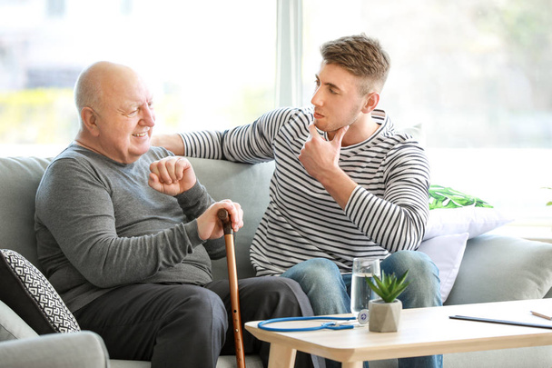 Cuidador masculino con un hombre mayor en un hogar de ancianos
 - Foto, Imagen