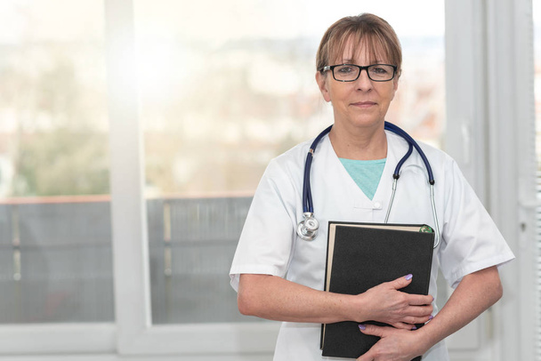 Médecin femme tenant un manuel médical
 - Photo, image