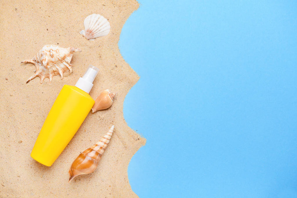 Sun protection cream with sand and seashells on color background - Φωτογραφία, εικόνα