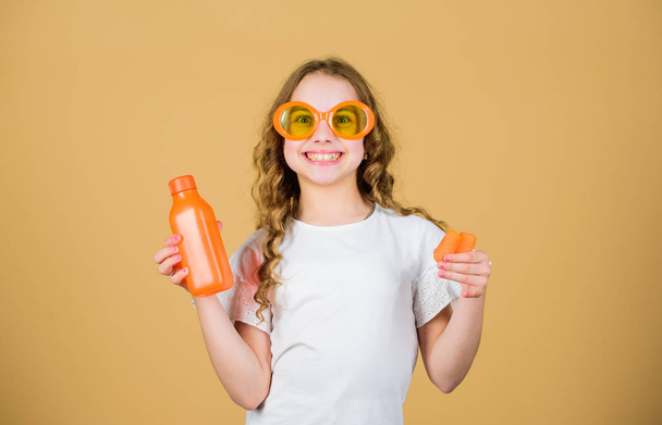 happy girl drink fresh carrot juice. summer vacation. little girl in fashion glasses. Vitamin nutrition. refreshing vitamin juice. Health. Summer vitamin diet. Natural vitamin source. Organic food - 写真・画像