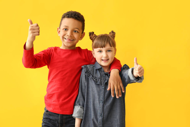 Portrait of cute children showing thumb-up on color background - Фото, зображення