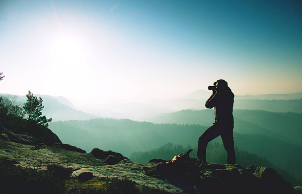 Photographer stay at tripod on summit. Man photographer during hike - Fotoğraf, Görsel