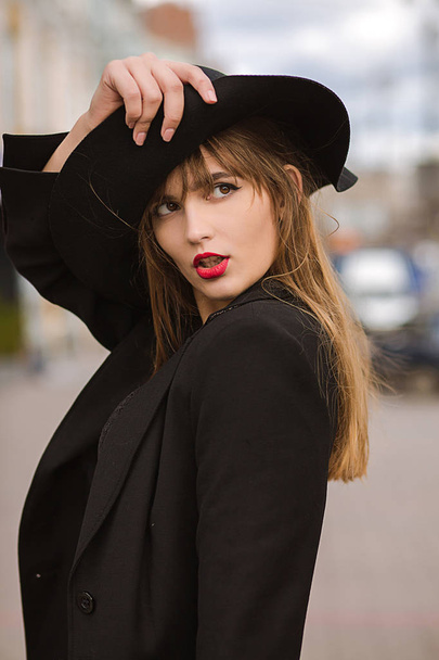 Foto de moda al aire libre de atractiva mujer joven con sombrero negro
 - Foto, Imagen