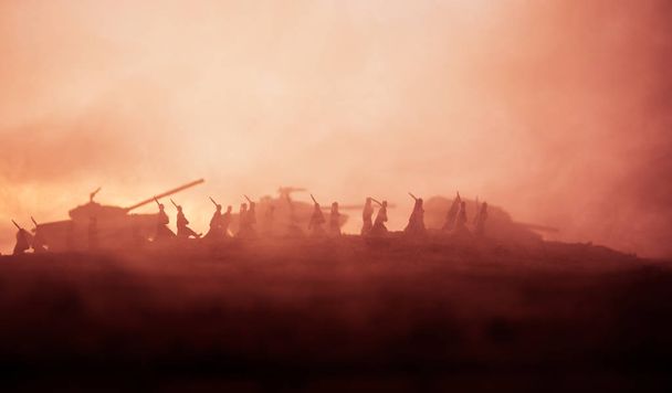 Concetto di guerra. Silhouette militari scena di combattimento su sfondo cielo nebbia di guerra, Soldati della Guerra Mondiale Silhouettes Below Cloudy Skyline al tramonto. Scena dell'attacco. Veicoli blindati
. - Foto, immagini