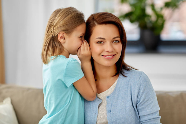 daughter whispering secret to mother at home - Photo, image