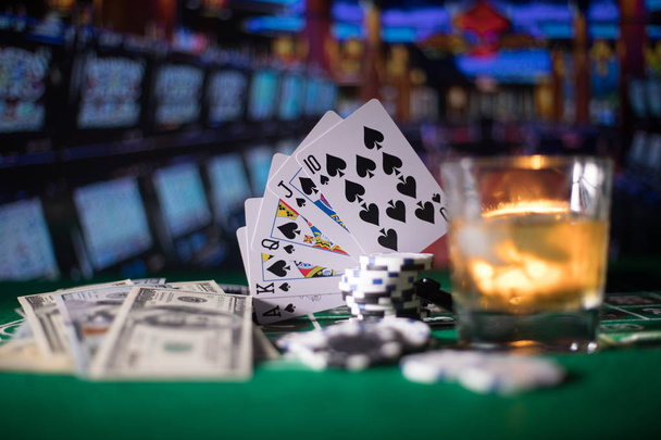 Glücksspiel, Vermögen, Spiel- und Unterhaltungskonzept - hautnah Casino-Chips und Whisky-Glas auf dem Tisch - Foto, Bild