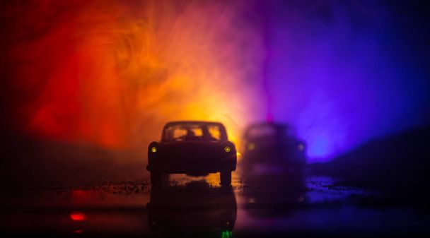 Auto della polizia a caccia di una macchina di notte con sfondo nebbia. 911 Auto della polizia di emergenza che accelera sulla scena del crimine. Focus selettivo - Foto, immagini