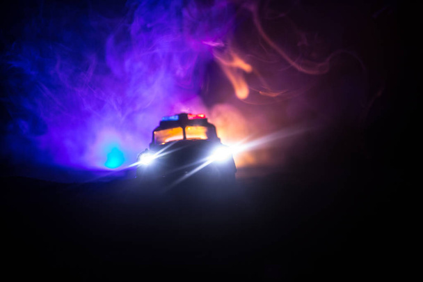 Поліцейські машини вночі. Поліцейський автомобіль переслідує машину вночі з тлом туману. 911 Аварійне реагування
 - Фото, зображення