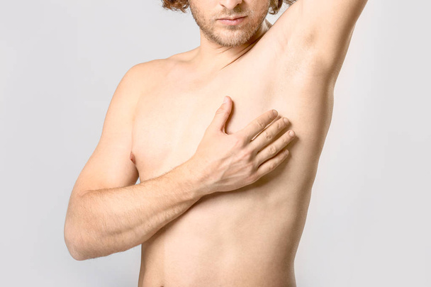 Hombre joven desnudo después de la depilación sobre fondo claro
 - Foto, imagen
