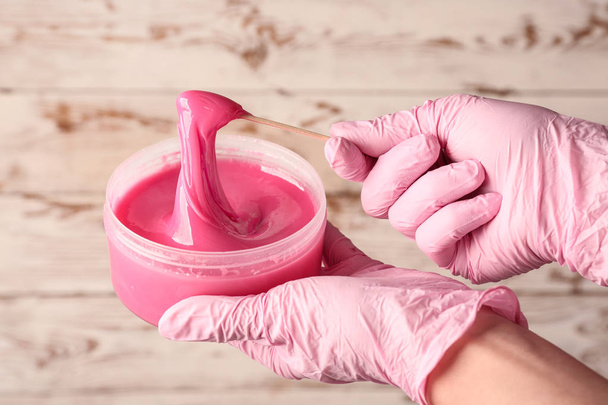 Female hands with sugaring paste for hair removal on wooden background - Foto, immagini