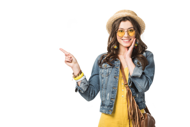 front view of smiling boho girl in denim jacket pointing with finger isolated on white - Foto, Bild