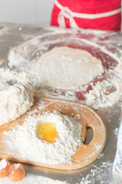 Baking concept. Flour and egg yolk on board on rustic wooden table, cooking ingredients. - 写真・画像