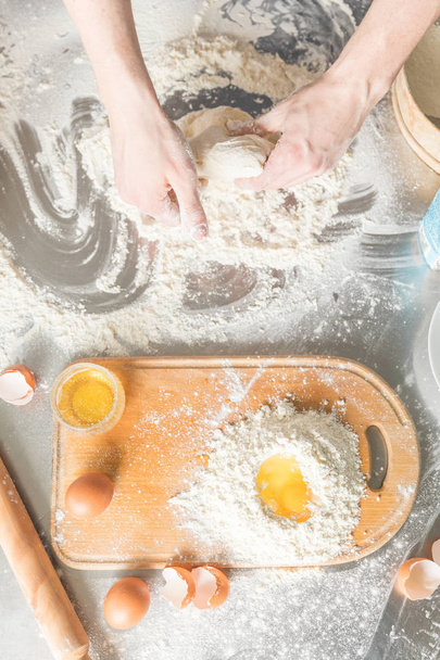 Baking concept. Flour and egg yolk on board on rustic wooden table, cooking ingredients. - 写真・画像