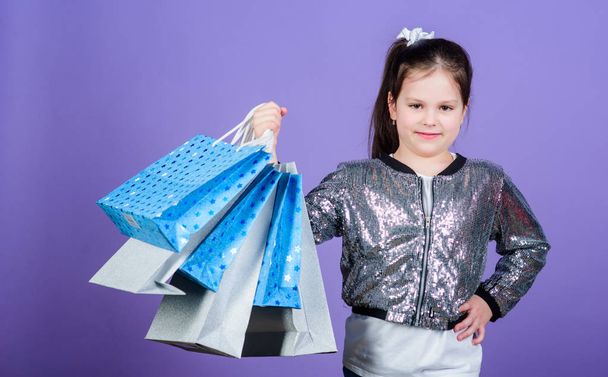 Great choices. Girl with shopping bags violet background. Shopping and purchase. Black friday. Sale discount. Shopping day. Child hold bunch packages. Kids fashion. Surprise gift. Great stores - Fotó, kép