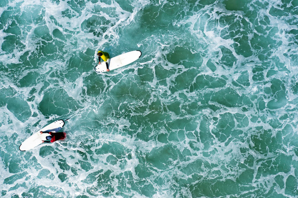 Aerial shot from surfers going to surf in the ocean - Foto, imagen
