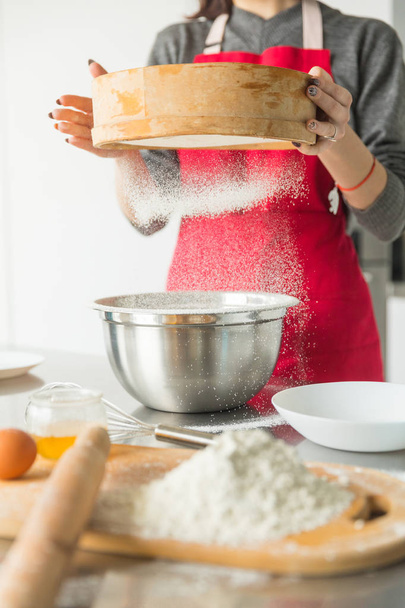 Woman hands sifting flour with flour filter - Foto, imagen