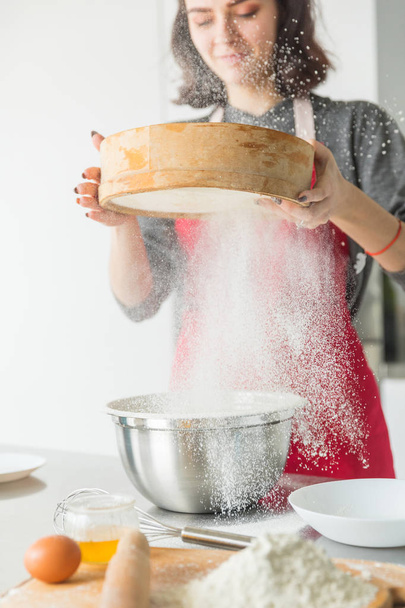 Woman hands sifting flour with flour filter - 写真・画像