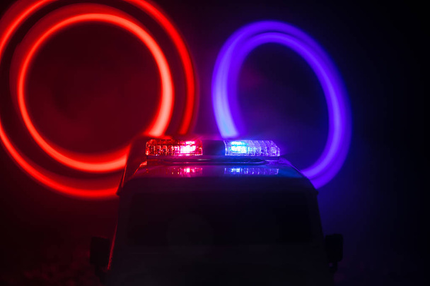 Polizeiautos in der Nacht. Polizeiwagen bei nächtlicher Verfolgungsjagd mit Nebelhintergrund. Selektiver Fokus auf Notfallmaßnahmen 911 - Foto, Bild