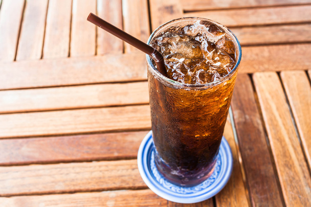 Soda negra fresca con hielo sobre mesa de madera
 - Foto, imagen